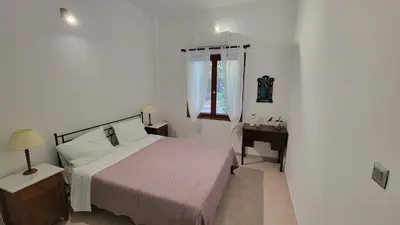 a white bedroom with a bed and a window at Aegean Villa & Garden in Faliraki in Faliraki