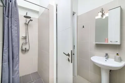 a white bathroom with a sink and a shower at Villa Mariani in Kalathos