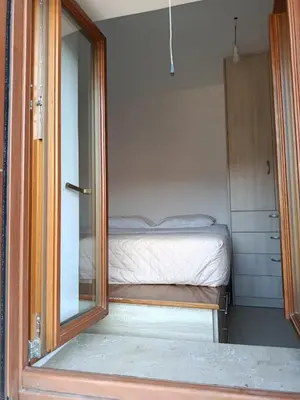 a small bedroom with a bed and a mirror at Doukissa's Apartment in Symi