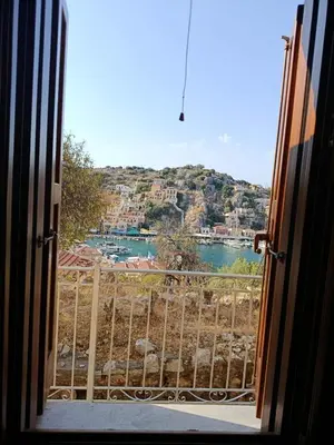 an open door with a view of a body of water at Doukissa's Apartment in Symi