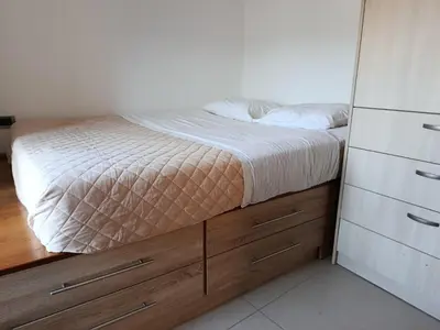 a small bedroom with a bed and a dresser at Doukissa's Apartment in Symi