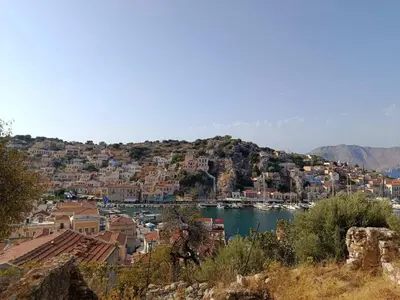 a town on a hill with a body of water at Doukissa's Apartment in Symi