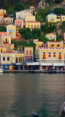 a group of houses on a hill next to the water at Doukissa's Apartment in Symi