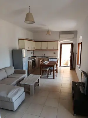 a kitchen and living room with a couch and a table at Doukissa's Apartment in Symi
