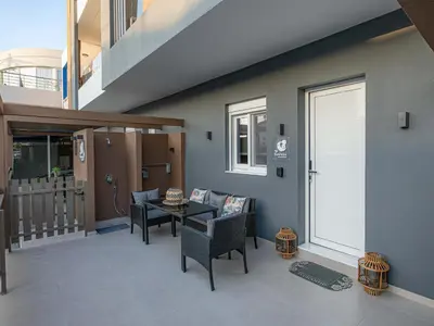 a living room with a table and chairs and a door at My Savvas Studios in Haraki
