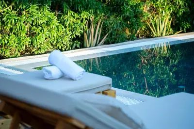 a lounge chair with a towel on it next to a pool at Eléa Blu Pool & Garden in Afantou