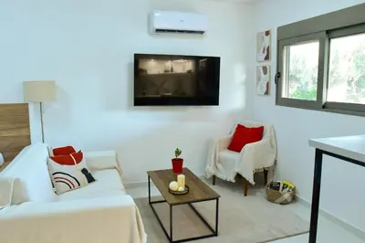 a living room with a white couch and two chairs at Eléa Blu Pool & Garden in Afantou