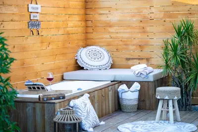 a bath tub sitting on a wooden wall with a table at Eléa Blu Pool & Garden in Afantou