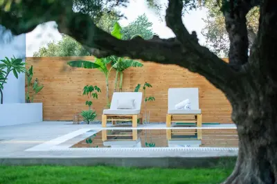 two white chairs sitting next to a fence at Eléa Blu Pool & Garden in Afantou