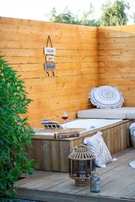 a hot tub on a deck with a wooden wall at Eléa Blu Pool & Garden in Afantou