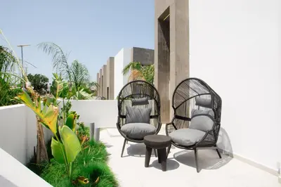 two chairs and a table on a balcony at Three Doors Villa Complex in Faliraki