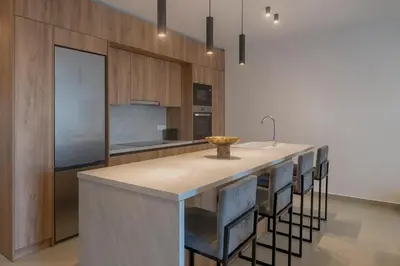 a kitchen with a island with a sink and some chairs at Ortus Luxury Residence in Rhodes Town