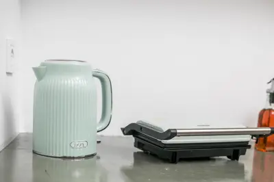 a white appliance sitting on top of a table at Niriana Verde Apartment in Gennadi