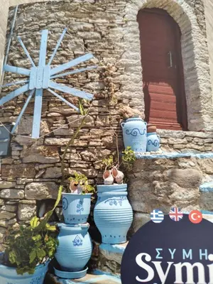 a group of blue vases sitting in front of a stone wall at The Windmill in Symi