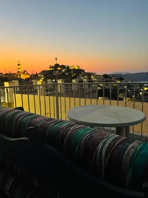 a table on a balcony with a view of a city at Villa Kastrouna, with private heated jacuzzi in Symi