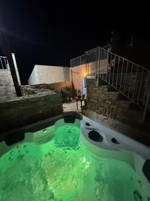 a hot tub in a yard at night at Villa Kastrouna, with private heated jacuzzi in Symi