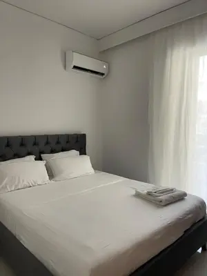 a bedroom with a large white bed with a window at Diagoras Suites in Rhodes Town