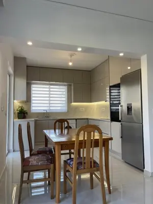 a kitchen with a table and chairs and a refrigerator at Diagoras Suites in Rhodes Town