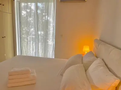a bed with white pillows and a lamp and a window at Diagoras Suites in Rhodes Town