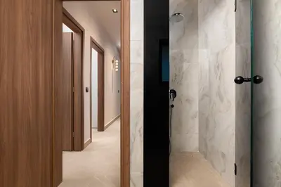 a bathroom with a walk in shower next to a hallway at Lanik Luxury Pool Villa in Afantou