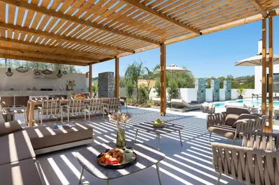 an outdoor patio with a wooden pergola at Lanik Luxury Pool Villa in Afantou
