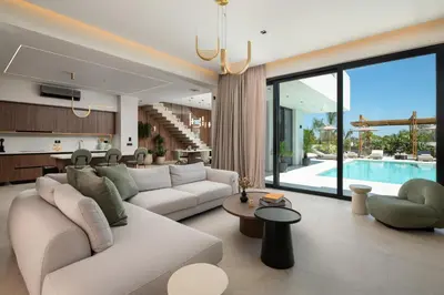 a living room with a couch and a kitchen and a pool at Lanik Luxury Pool Villa in Afantou