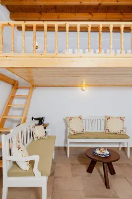 a room with two white chairs and a staircase at Ikia Damianou Traditional House in Archangelos