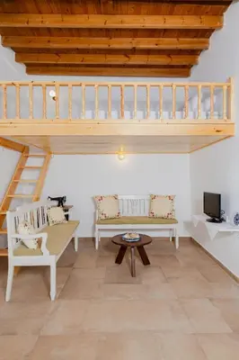 a living room with two chairs and a staircase at Ikia Damianou Traditional House in Archangelos
