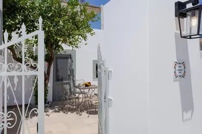 a white house with a white fence and a table at Ikia Damianou Traditional House in Archangelos