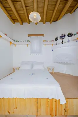 a bedroom with a large white bed in a room at Ikia Damianou Traditional House in Archangelos