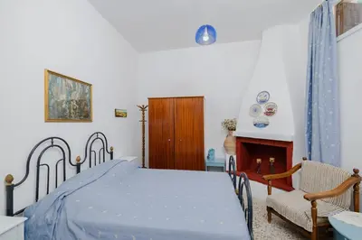 a bedroom with a bed and a chair and a fireplace at Statis House in Lardos