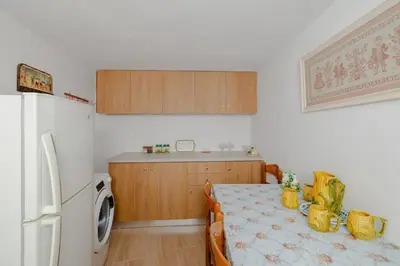 a kitchen with a table and a white refrigerator at Statis House in Lardos