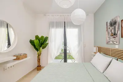 a white bedroom with a bed and a window at Anna Maria Suite in Rhodes Town