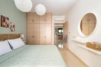 a bedroom with a large bed and two round mirrors at Anna Maria Suite in Rhodes Town