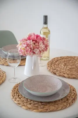 a table with plates and a vase of flowers and a bottle of wine at Anna Maria Suite in Rhodes Town