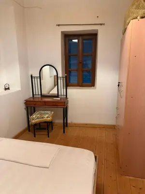 a bedroom with a dressing table and a mirror at Melitsaka in Nikiá