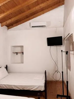a bedroom with a bed and a tv on the wall at Melitsaka in Nikiá