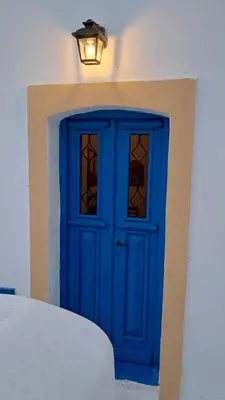 a blue door on a building with a light above it at Melitsaka in Nikiá