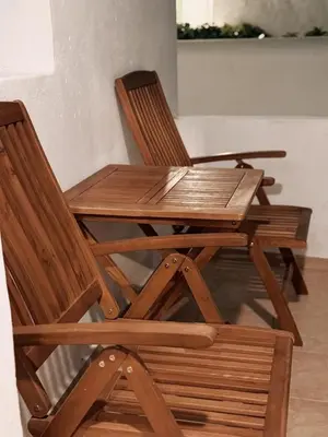 two wooden chairs and a wooden table and a table and chairs at Melitsaka in Nikiá