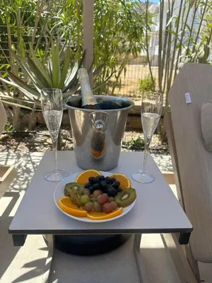 a plate of fruit on a table with two wine glasses at Le Soleil De Lindos - Luxury Villa with Swim Spa in Líndos