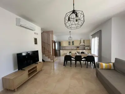 a living room with a television and a dining room at Le Soleil De Lindos - Luxury Villa with Swim Spa in Líndos