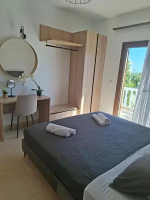 a bedroom with a bed and a desk and a mirror at Le Soleil De Lindos - Luxury Villa with Swim Spa in Líndos