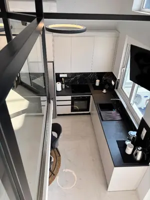 a kitchen with white cabinets and a black counter top at Kyra Maria 3, Loft in Rhodes Town