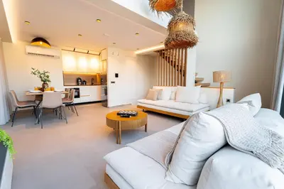 a living room with a white couch and a table at Etheras 2 - Holiday Apartments in Asgourou