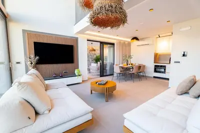 a living room with a white couch and a tv at Etheras 2 - Holiday Apartments in Asgourou