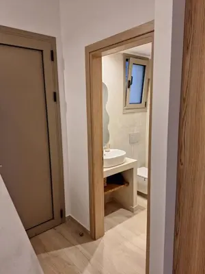 a bathroom with a door leading to a sink at VILLA PAVA MARE sea view brand new 2025 in Vrachonisída touArchangélou