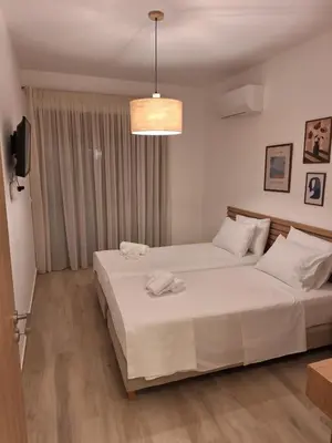 a bedroom with two beds and a pendant light at VILLA PAVA MARE sea view brand new 2025 in Vrachonisída touArchangélou