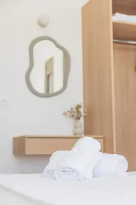 a pile of towels on a bed with a mirror at VILLA PAVA MARE sea view brand new 2025 in Vrachonisída touArchangélou