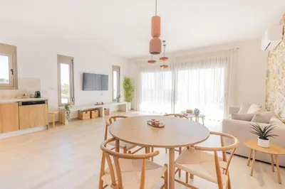 a living room with a table and chairs and a couch at VILLA PAVA MARE sea view brand new 2025 in Vrachonisída touArchangélou