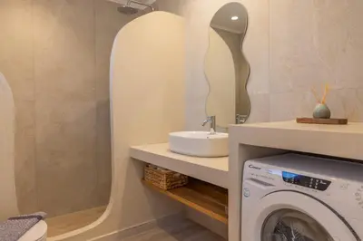 a bathroom with a sink and a washing machine at VILLA PAVA MARE sea view brand new 2025 in Vrachonisída touArchangélou